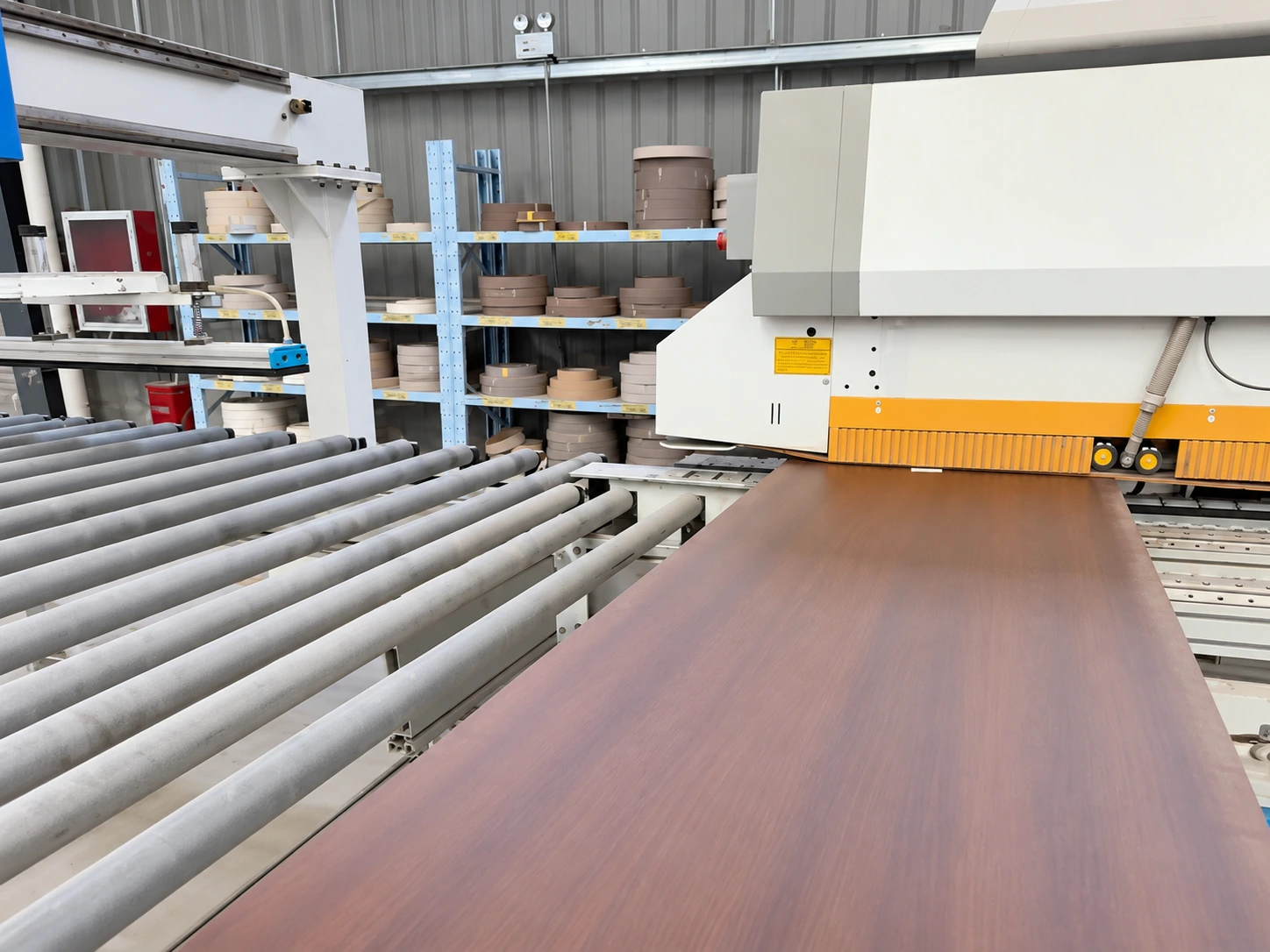 Wooden door panel passing through edge-banding equipment